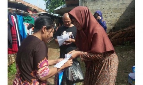 Dosen BSI kampus Fatmawati menyerahkan bingkisan lebaran kepada salah seorang  dhuafa di Lebak Bulus, Jakarta Selatan, Jumat (1/7/2016).