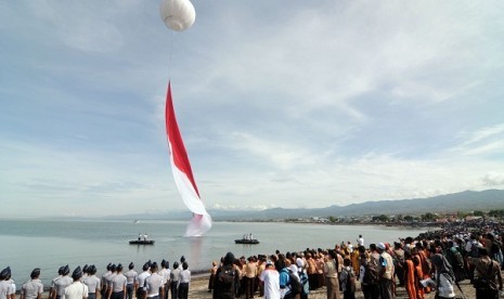 Dozens thounsands of people watch the Indonsian flag hoisting ceremony in Palu Bay in Central Sulawesi on Saturday, Dec. 14, 2013. The flag which is 1000 meter square emerges from underwater and this attraction is part of the Archipelago Day 2013.