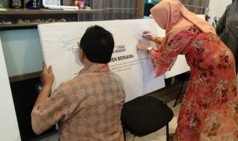 Dr Dwiza Riana dan Sigit Swasono saat menandatangani simbolis komitmen bersama seluruh civitas akademik STMIK Nusa Mandiri untuk melaksanakan Sistem Penjamin Mutu Internal (SPMI).