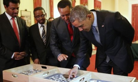 Dr. Zeresenay Alemseged Lemseged (dua dari kanan), dari California Academy of Sciences, meminta Presiden Barack Obama (kanan) untuk menyentuh fosil kerangka leluhur Lucy, manusia purba, sebelum jamuan kenegaraan di Addis Ababa (28/7). 