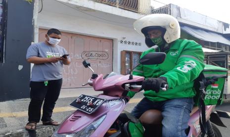 Driver ojol mengantarkan makanan ke konsumen. Menurut Buya Yahya, driver ojol tak berdosa jika mengambil orderan makanan nonhalal dari 