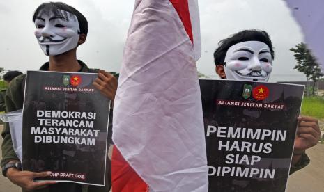 Dua aktivis mahasiswa yang tergabung dalam Aliansi Jeritan Rakyat (Ajra) berunjuk rasa mengecam ketertutupan pemerintah dan DPR saat melakukan pembahasan draft rancangan Kitab Undang-undang Hukum Pidana (RKUHP) di Alun-alun Serang, Banten, Rabu (6/7/2022). Mereka menuntut pemerintah dan DPR mempublikasikan draft rancaangan KUHP tersebut selama masa pembahasan secara terbuka untuk dikritisi publik supaya rakyat bisa turut berpartisipasi dan memberikan aspirasi mereka. 