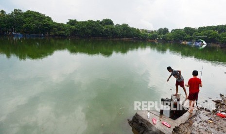 Dua anak memancing di Danau Sunter, Jakarta, Kamis (18/1). 