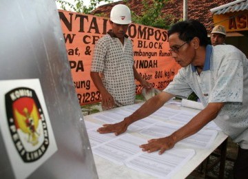 Dua anggota KPPS menyiapkan Tempat Pemungutan Suara (TPS).