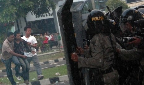 Dua anggota polisi berpakaian preman menangkap seorang mahasiswa ketika berlangsungnya demonstrasi tolak Kenaikan harga BBM di depan kantor DPRD Sumbar di Padang, Kamis (29/3). 