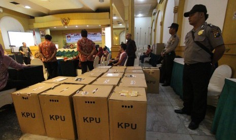 Dua anggota polisi menjaga kotak kertas suara saat berlangsungnya rekapitulasi perolehan suara hasil pilpres