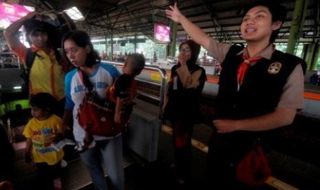 Dua anggota Pramuka memberikan arahan kepada pemudik Kereta Api di Stasiun Gambir, Jakarta, Senin (5/8).