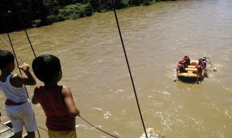 Dua bocah menyaksikan salah satu tim yang mengikuti ajang Musi Triboatton 2014