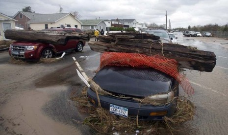  Dua buah mobil yang tertimpa pohon setelah diterjang Badai Sandy di New York, Selasa (30/10).    (Keith Bedford/Reuters)