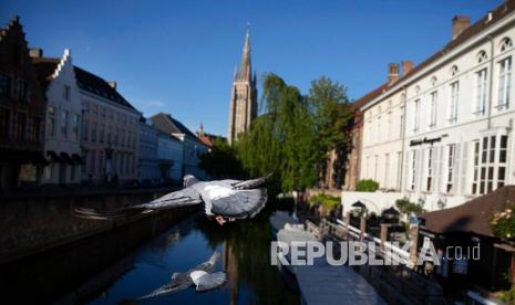 Dua ekor burung merpati terbang melintasi sungai di Bruges selama masa lockdown guna mencegah penyebaran coronavirus atau COVID-19, Rabu (13/5). Pembatasan selama masa lockdown akibat pandemi COVID-19 membuat sektor pariwisata mengalami penurunan pengunjung di beberapa Negara di Eropa menjelang musim panas atau musim berlibur. 