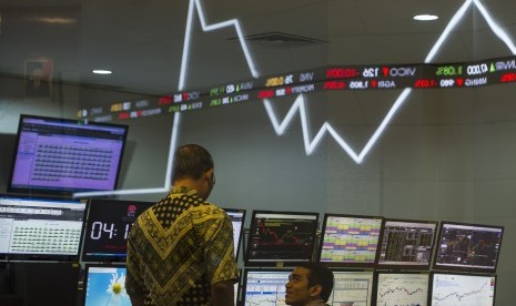 Dua karyawan mengamati pergerakan Indeks Harga Saham Gabungan (IHSG) di Bursa Efek Indonesia, Jakarta, Jumat (22/4). 