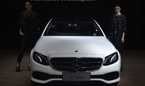 Dua model berpose di samping Mercedes-Benz The New E-Class saat peluncurannya pada Gaikindo Indonesia International Auto Show di ICE BSD, Tangerang Selatan, Banten, Kamis (11/8). 