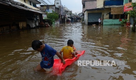  Dua orang anak bermain air saat banjir di Wilayah Duren Bangka, Jakarta Selatan, Kamis (21/4). (Republika/Raisan Al Farisi)