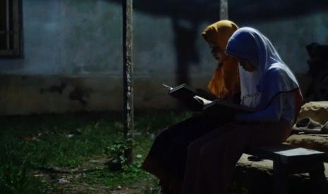 Dua orang anak di pedalaman Kalimantan Barat tengah mengaji di depan rumah.