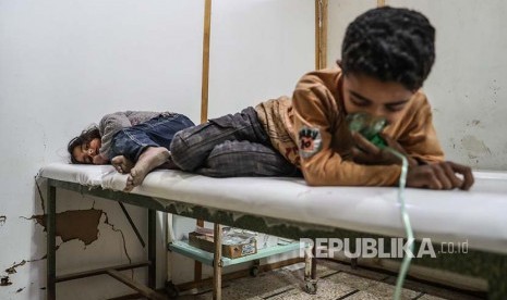 Dua orang anak memperoleh penanganan medis setelah terpapar gas beracun di Desa Shifunieh, Ghouta Timur, Suriah, Ahad (25/2).