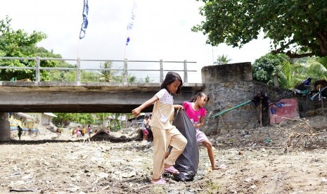 Dua orang anak mengikuti lomba membersihkan sampah yang digelar oleh Generasi Baru Indonesia (GenBI) di obyek wisata Olele, Kabupaten Bone Bolango, Gorontalo, Minggu (16/12/2018).