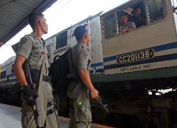 Dua orang anggota Brimob, berkomunikasi dengan masinis di Stasiun Senen, Jakarta, Ahad (28/8).