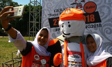 Dua orang calon pemilih pemula berswafoto dengan maskot Pilkada Kota Tangerang yang bernama Si Bentos usai launching tahapan Pilkada Serentak Kota Tangerang di Tangerang, Banten, Senin (20/11). 