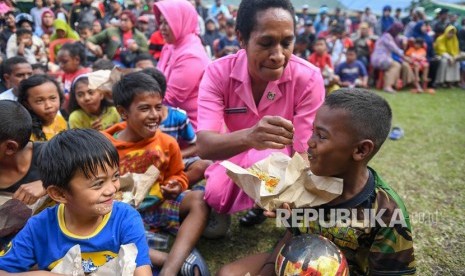 Dua orang Ibu Bhayangkari menyuapi makan pada bocah pengungsi di Posko pengungsian di Makodim 1702/Jayawijaya, Wamena, Papua, Selasa (8/10/2019).