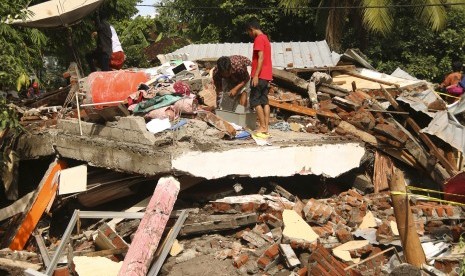 Dua orang laki-laki mencari sisa-sisa barang yang bisa diselamatkan salah satu rumah warga yang ambruk akibat diterjang banjir bandang di Desa Sepit, Keruak, Selong, Lombok Timur, NTB, Ahad (19/11).