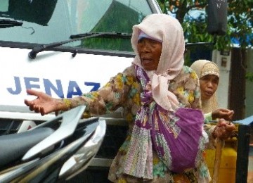 Dua orang pengemis meminta-minta di pekarangan masjid di kawasan Bendungan Hilir, Jakarta.