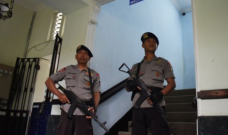 Dua orang personel Brimob bersenjata panjang menjaga tangga menuju ruang kerja Walikota Madiun Bambang Irianto saat tim Komisi Pemberantasan Korupsi (KPK) melakukan penggeledahan, di Madiun, Jawa Timur, Senin (17/10).