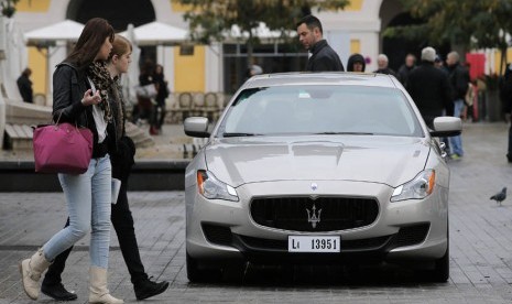 Dua orang wanita melihat mobil model terbaru Maserati Quattroporte di kota Nice,Perancis, Selasa (4/12).  (AP/Lionel Cironneau)