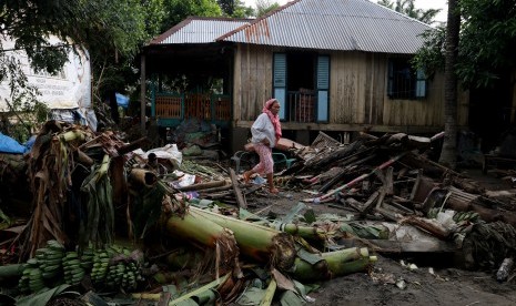 Dua orang warga berada di depan rumah mereka yang terkena dampak banjir yang terjadi di Jalan Imam Bonjol, Binjai, Sumatera Utara, Rabu (10/2). 