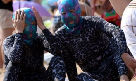 Dua Orang Warga Cina Tengah Berlibur di Pantai Berpakaian Renang ALa Alien 