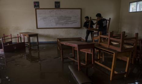 Dua orang warga membersihkan ruangan kelas yang terendam lumpur akibat banjir bandang Sungai Cimanuk di Sekolah PGRI Garut, Jawa Barat, Sabtu (16/7/2022). Banjir bandang akibat luapan Sungai Cimanuk saat intensitas curah hujan yang tinggi pada Jumat (15/7) kemarin mengakibatkan sejumlah sekolah hingga rumah ibadah rusak berat.