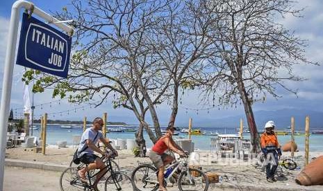 Dua orang wisatawan asing mengendarai sepeda di kawasan wisata Gili Trawangan, Desa Gili Indah, Kecamatan Pemenang, Tanjung, Lombok Utara, NTB, Rabu (8/8). Pascagempa yang melanda daerah Lombok Utara, sebagian wisatawan asing memilih tetap tinggal di kawasan wisata Gili Trawangan.