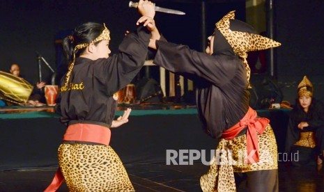 Dua para pesilat wanita tampil memperagakan pertarungan dengan senjata pada 'Gelar Pendekar Wanita' oleh Masyarakat Pencak Silat Indonesia (Maspi) dan Taman Budaya Jabar, di Teater Terbuka Taman Budaya Jabar, Bandung, Sabtu (2/3). (Republika/Edi Yusuf)