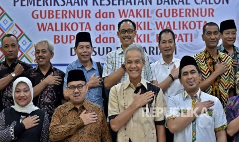 Dua pasangan bakal cagub-cawagub Jawa Tengah Ganjar Pranowo (kedua kanan, depan)- Taj Yasin (kanan, depan) dan Sudirman Said (kedua kiri, depan)-Ida Fauziyah (kiri, depan), berfoto bersama sejumlah bakal cabup-cawabup dalam pilkada Jateng, sebelum menjalani tes kesehatan di RSUP Kariadi Semarang, Jawa Tengah, Jumat (12/1).