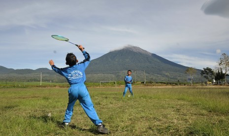 Dua pelajar SDN 221 Kabupaten Kerinci bermain bulu tangkis dengan latar Gunung Kerinci di Lindung Jaya, Kayu Aro, Kerinci, Jambi. Indonesia dinilai perlu memiliki sekolah khusus olahraga untuk mencetak atlet berprestasi.