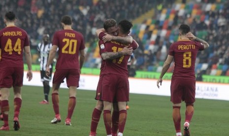 Dua pemain AS Roma, Cengiz Under dan Danielle de Rossi (tengah) berpelukan merayakan gol ke gawang Udinese pada laga Serie A di Darcia Arena, Sabtu (17/2). Roma menang 0-2.