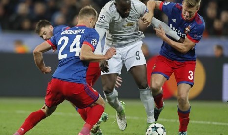 Dua pemain CSKA Moskow, Vasili Berezutski (kiri) dan Pontus Wernbloom (kanan), berusaha mengadang striker Manchester United Romelu Lukaku ketika kedua tim saling berhadapan pada Liga Champions Grup A di VEB Arena, Moskow, Rusia, Kamis (28/9) dini hari WIB. 