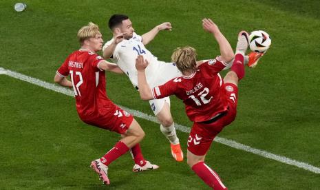 Dua pemain Denmark, Victor Kristansen (kiri) dan Kasper Dolberg (kanan), berebut bola dengan pemain Serbia Andrija Zivkovic dalam pertandingan terakhir Grup C Euro 2024 di Allianz Arena, Munchen, Rabu (26/6/2024) dini hari WIB.