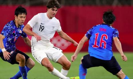 Dua pemain Jepang Yuki Soma (kiri) dan Wataru Endo (Kanan) mencoba menghentikan pergerakan Matthew Garbett dalam pertandingan perempat final sepak bola Olimpiade Tokyo 2020 di Ibaraki Kashima Stadium, Jepang pada 31 Juli 2021. 