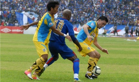  Dua pemain Persegres, Habib Syukron (kiri) dan Matsunaga (kanan), menjaga pergerakan pemain Arema, Keith Kayamba Gumbs, dalam pertandingan kompetisi Indonesia Super League (ISL) di stadion Petrokimia Gresik, Jawa Timur, Kamis (7/3). 