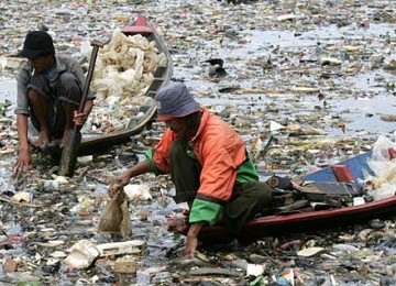 Dua pemulung sedang mencari sampah plastik di sungai yang sudah dipenuhi sampah. (Ilustrasi)