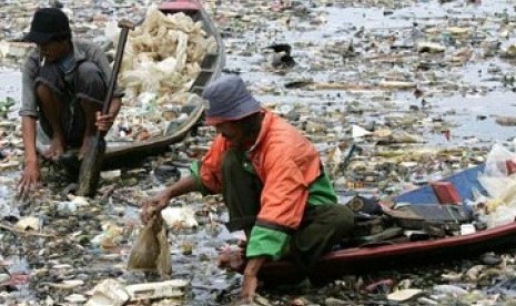 Dua pemulung sedang mencari sampah plastik di sungai yang sudah dipenuhi sampah. (Ilustrasi)