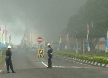 Dua penjaga keamanan di Pertamina Cilacap, sedang berjaga-jaga di jalan masuk komplek kilang. 