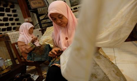 Dua perajin membuat batik tulis di Batik Gunawan Kampung Batik Kauman Solo, Jawa Tengah, Rabu (14/9/2022). Kampung Batik Kauman tersebut selain Laweyan merupakan salah satu pusat batik tertua di Solo yang mengembangkan bisnis pariwisata dengan menyediakan pelatihan singkat membatik bagi wisatawan.