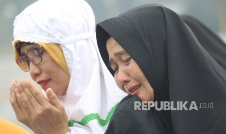 Dua perempuan menangis seusai melaksanakan Sholat Istisqa (salat minta hujan) di halaman Makodam XII/Tanjungpura di Kabupaten Kubu Raya, Kalbar, Selasa (17/9/2019).