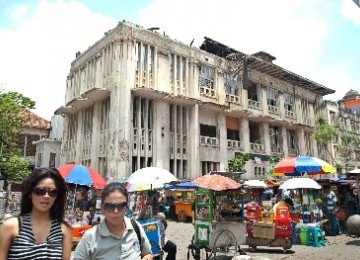 Dua perempuan, pengunjung kawasan Kota Tua Jakarta, berjalan di antara pedagang kakilima di kawasan Taman Fatahillah, Jakarta.