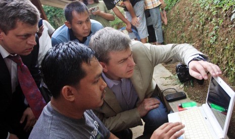 Dua personel tim Invesigasi Rusia melihat gambar-gambar lokasi jatuhnya pesawat Sukhoi Superjet 100 dari pewarta foto di Cijeruk, Bogor, Jawa Barat, Jumat (10/5). Komite Nasional Keselamatan Transportasi bersama tim investigasi dari KNKT Rusia akan menyeli