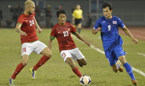 Dua pesepakbola timnas Diego Robbie Michiels (kiri) dan Bayu Gatra Sanggiawan berusaha merebut bola dari pemain Thailand Adisak Kraisorn (9) pada  final Sepakbola SEA Games ke-27 di Naypyitaw, Sabtu (21/12).  (/Antara/Widodo S. Jusuf)