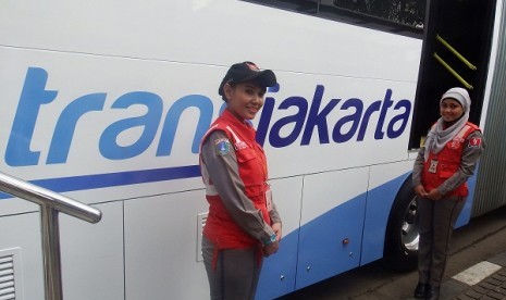  Dua petugas Transjakarta di samping logo baru Transjakarta yang resmi diluncurkan usai upacara Hari Pahlawan 10 November di Lapangan Barat Monas, Jakarta, Senin (10/11).