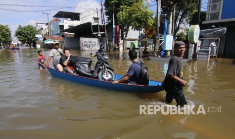 Dua pria menarik perahu yang disewakan untuk mengangkut warga dan motor dari kawasan Jalan A Yani yang terendam banjir di Samarinda, Kalimantan Timur, Rabu (12/6/2019).