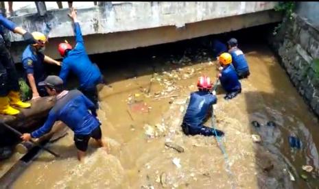 Dua regu Satgas Banjir dari Dinas PUPR Kota Depok membersihkan sampah dan mengangkat satu batang pohon yang menyumbat aliran air di Kali Licin sehingga kali meluap hingga menggenangi Jalan Sawangan dan Jalan Pramuka Mampang, Kota Depok, Kamis (23/9).